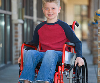 boy smiling while sitting in wheelchair