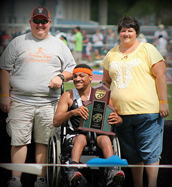 Drew Dees shows off his award with his parents