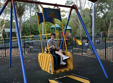 Julie's son on a wheelchair accessible swing