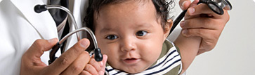 doctor holding baby's arms up during exam