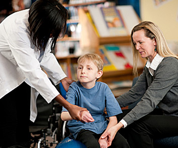 Boy during therapy session using large therapy ball