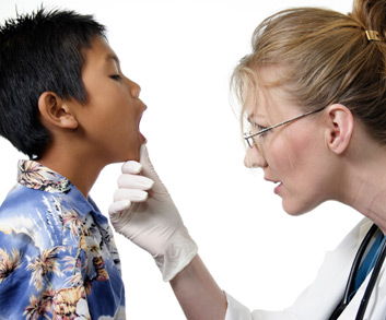 Doctor checking boy’s facial muscles